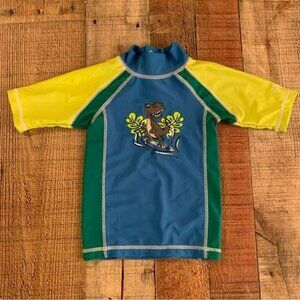 UV skins boys rashguard with surfing dinosaur in blue and green -12/18M